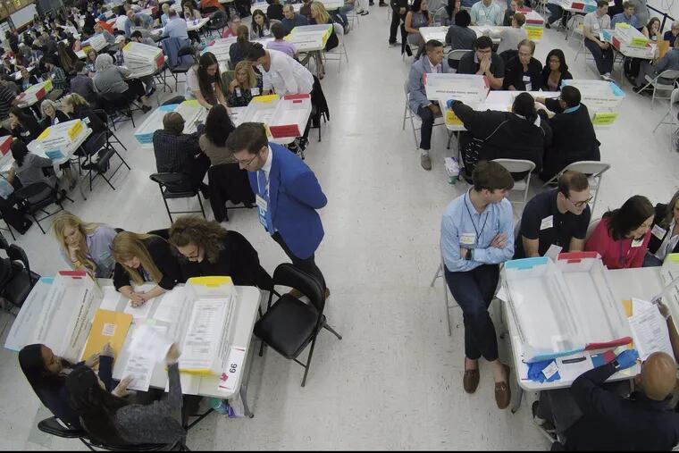 Workers at the Broward County Supervisor of Elections office recount votes by hand in front of observers Nov. 16.