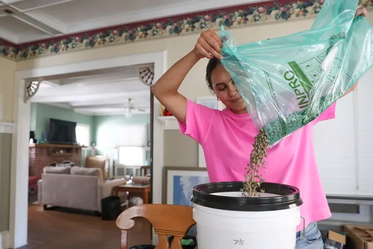 Amanda Escobar pours into a bucket the latest shipment of coffee beans from Colombia that they received for Remedee, a small-batch craft coffee roastery she runs out of the garage of her family’s Bartram Ave. beach home with sister Colie Escobar in Atlantic City, NJ on Saturday, July 23, 2022.