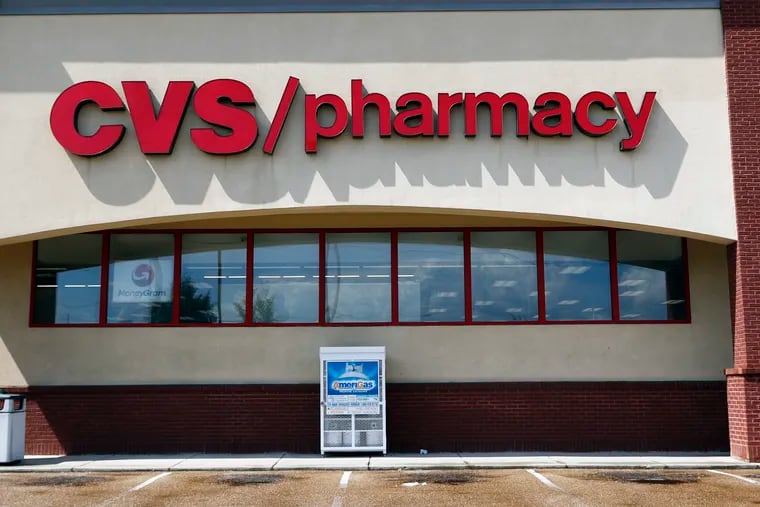 FILE- In this Aug. 7, 2018, file photo a CVS Pharmacy building sign rests on a store.