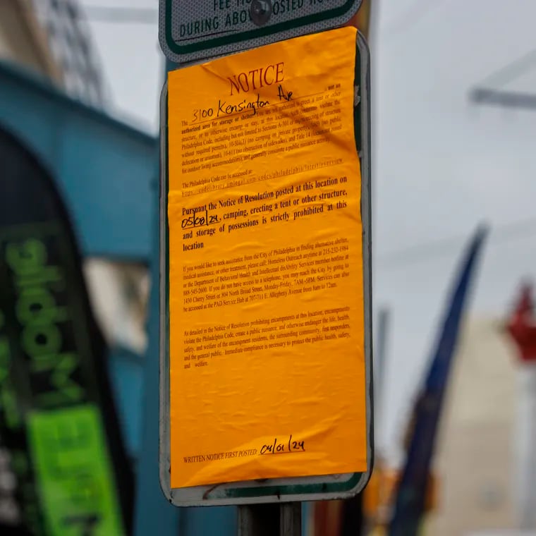 A sign informing people along Kensington Avenue that on Wednesday, May 8, the city will be removing tents and other structures from the avenue.