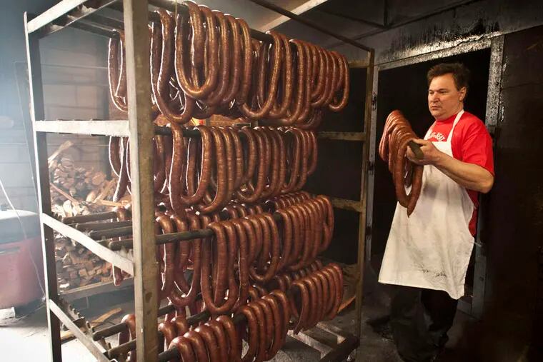 John Czerw pulls a kielbasa from the smokehouse at Czerw's, Tilton Street. Easter is a busy time at Czerw's, Swiacki's, Stock's, and other fixtures of Port Richmond's Polish comunity.