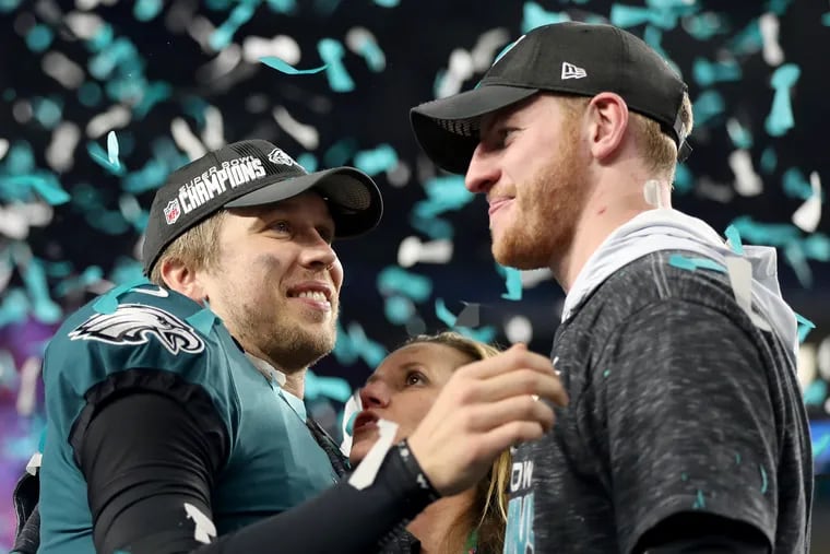 Carson Wentz and Nick Foles celebrate during the postgame ceremony after the Eagles defeated the New England Patriots in Super Bowl LII at U.S. Bank Stadium in Minnesota.