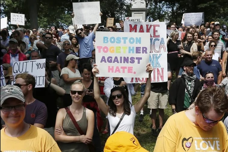 Counterprotesters hold signs at a “Free Speech” rally by conservative activists on Boston Common on Aug. 19.