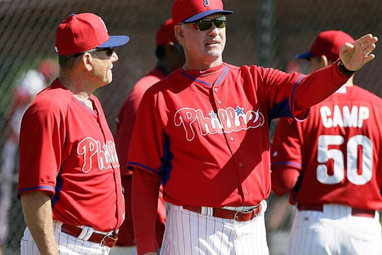 Phillies manager Ryne Sandberg talks with bench coach Larry Bowa, left, during spring training baseball practice Wednesday, Feb. 19, 2014, in Clearwater, Fla. (Charlie Neibergall/AP)