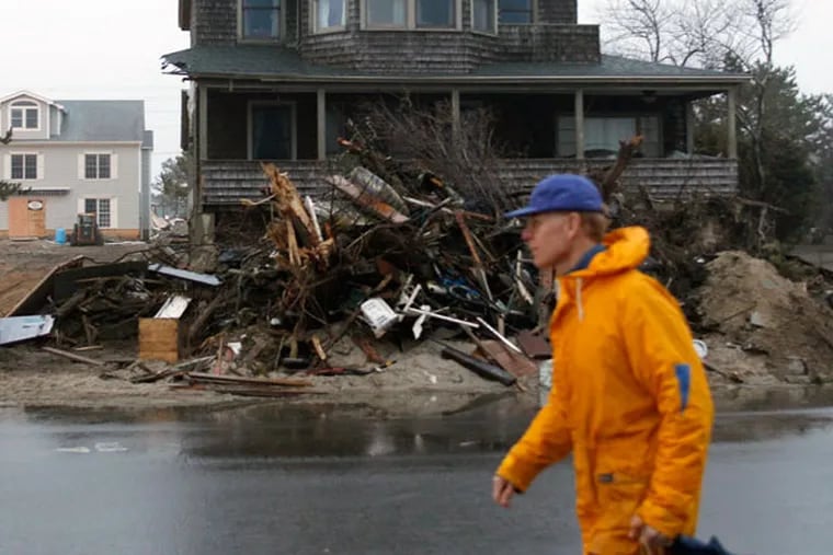 Storm debris was stacked high outside a home in Mantoloking, Ocean County, two months after Hurricane Sandy struck in October 2012. (YONG KIM/Staff Photographer)