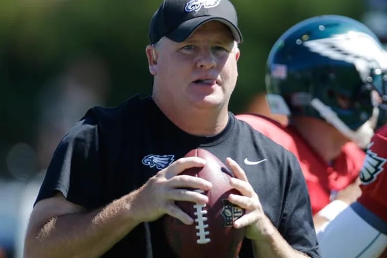 Chip Kelly and quarterback Michael Vick throws a passes during NFL football practice at the team's training facility, Wednesday, Sept. 4, 2013, in Philadelphia. (Matt Rourke/AP)