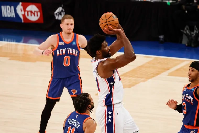Sixers center Joel Embiid is surrounded by 'Nova Knicks Donte DiVincenzo (0), Jalen Brunson, and Josh Hart (3) during Game 5 of their playoff series on April 30.