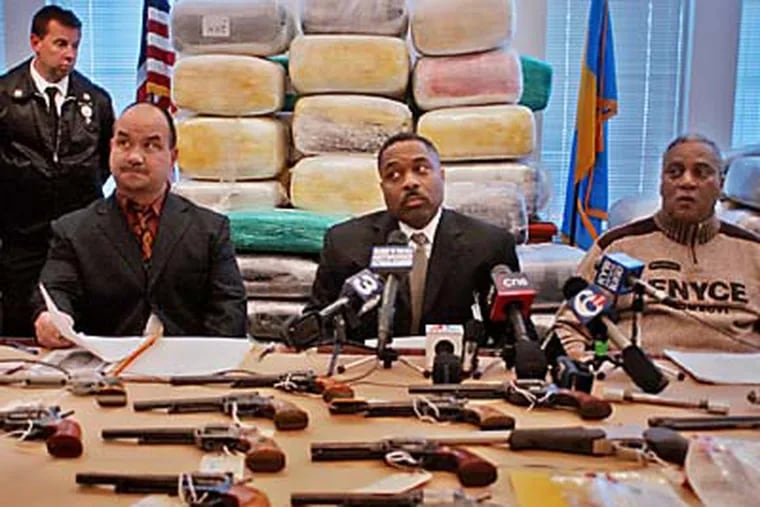 In this file photo, William C Blackburn- Chief Inspector Narcotics Bureau, Inspector Aaron Horne - Commanding Officer Narcotics Division and Police Chief Sylvester Johnson showed 120 bales of marijuana worth $11.5 million and a table full of weapons. (John Costello / For the Inquirer)