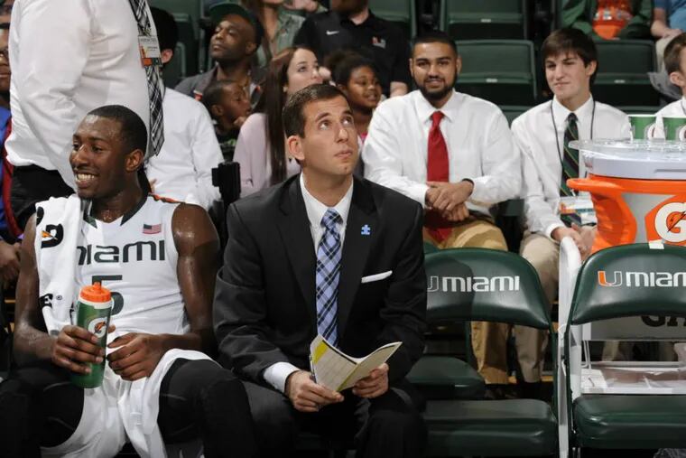 Miami assistant coach Adam Fisher on bench with guard Davon Reed.