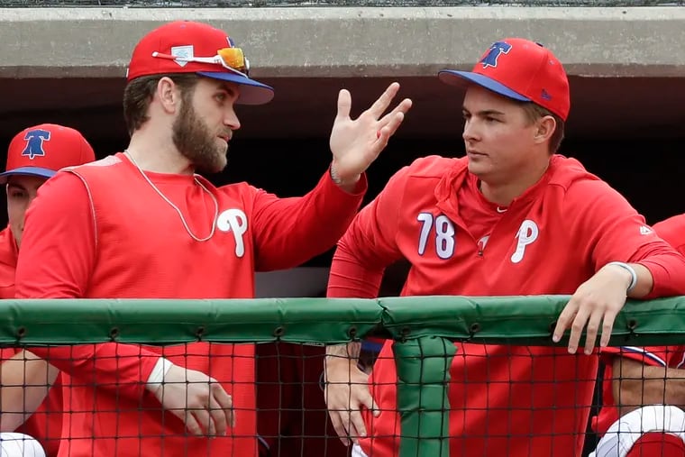Bryce Harper offers some advice to center fielder Mickey Moniak, who is expected to begin the season at double A.