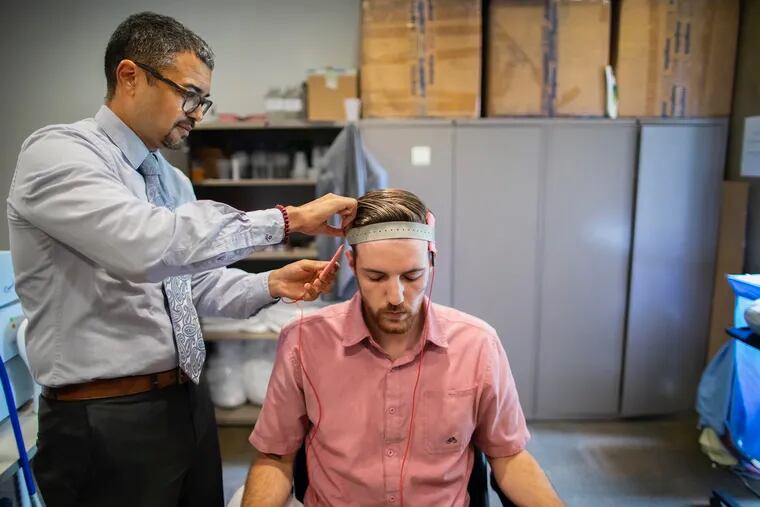 Dr. Roy Hamilton demonstrates the setup for transcranial direct current stimulation.
