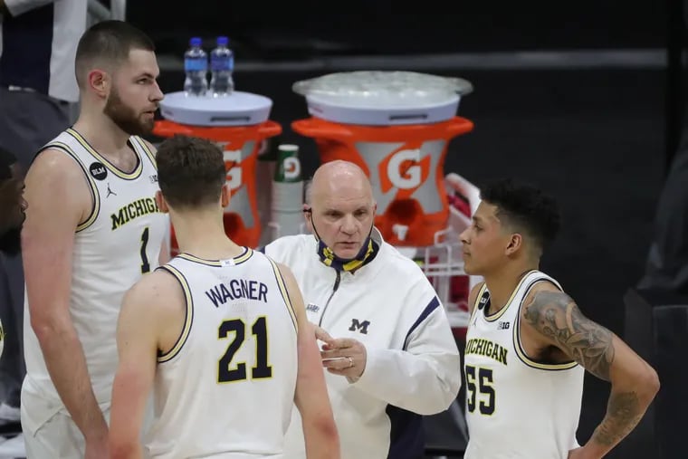 Michigan Wolverines assistant coach Phil Martelli talks with  center Hunter Dickinson (1) and guards Franz Wagner (21) and Eli Brooks (55) on the bench during Friday's Big Ten tournament game against Maryland.