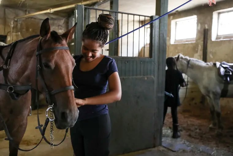 Jordyn Williams, 12, gets the horses ready at the Northwestern Stables in Philadelphia on Saturday, July 22, 2023. Work to Ride is a Philly nonprofit that teaches kids horsemanship as a path to a strong future.