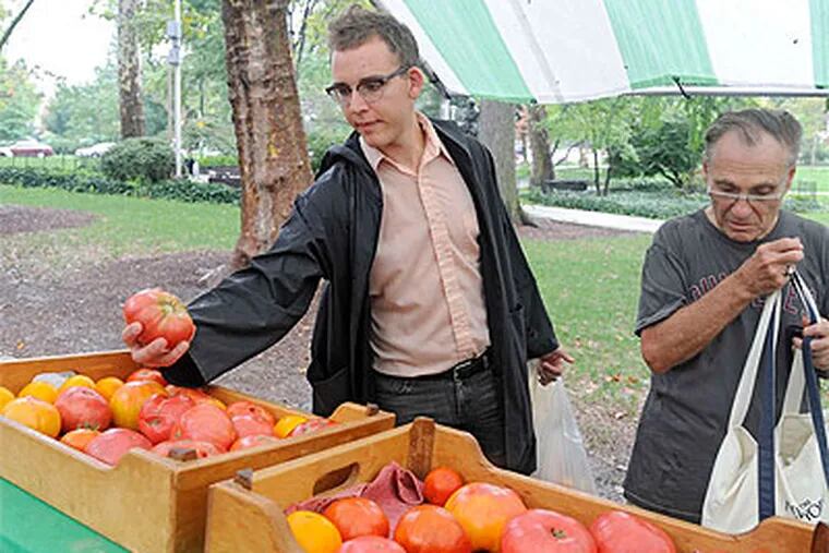 Bench Ansfield (left) shops at a farmers market in Clark Park. Farmers markets bring fresh food to the public. (Clem Murray / Staff Photographer)