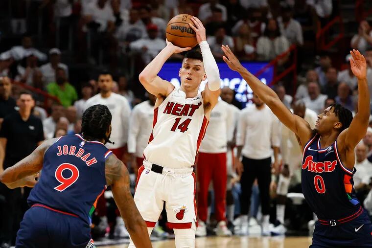 Miami Heat guard Tyler Herro looks to pass the basketball against Sixers guard Tyrese Maxey and center DeAndre Jordan.