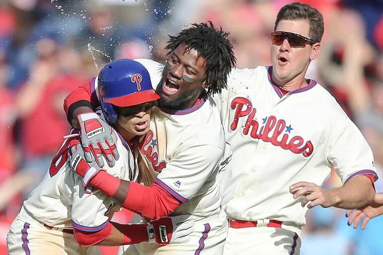 Cesar Hernandez celebrates with teammates Odubel Herrera and Tommy Joseph after a walk-off base hit to beat the Nationals.