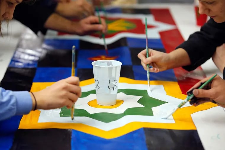 Community volunteers paint parts of mural at the Al-Aqsa Islamic Society on Saturday, January 9, 2016 in Philadelphia.