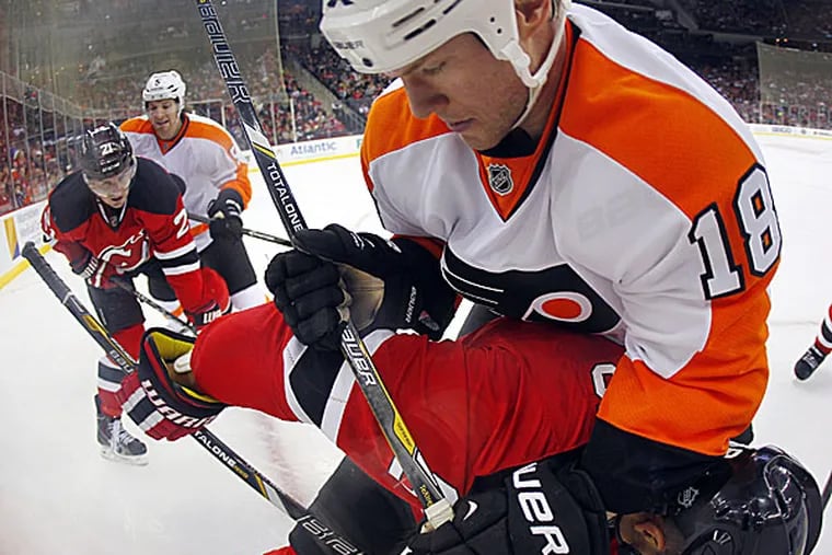The Flyers' Adam Hall checks the Devils' Dainius Zubrus into the boards during the second period. (Rich Schultz/AP)