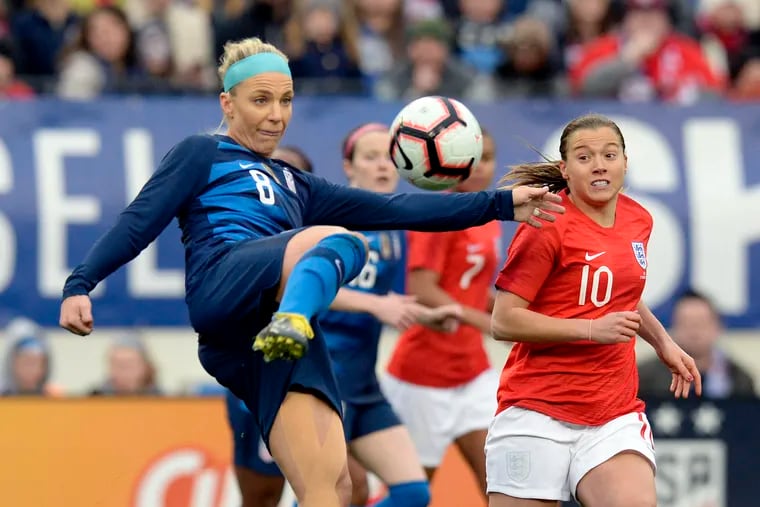 United States midfielder Julie Ertz tries to control a loose ball with England's Fran Kirby in pursuit.