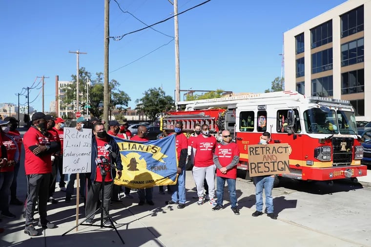 A fire truck drives past as retired battalion chief Joaquin Colon speaks during a protest by members of the International Association of Fire Fighters Local 22 outside the union's building in Philadelphia's Callowhill section on Thursday.