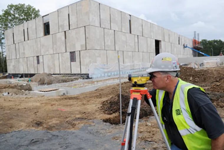 Tom McCarthy of L.F. Driscoll Co. takes a measurement at the Barnes museum site on the Parkway. (Clem Murray / Staff Photographer)