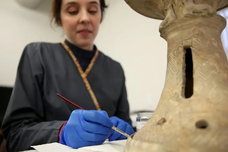 At the Penn Museum, Marci Burton applies a gel emulsion to clean a vessel stand from the ancient Mesopotamian city of Ur. The artifact, which dates to about 2400 B.C., is being readied for a new exhibit that opens in April.