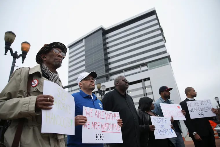 Activists and community leaders stand during a news conference, arguing that developments that received tax breaks should benefit longtime residents in Camden, N.J. The new high-rise office tower on Camden's waterfront was approved for $245 million in tax breaks.