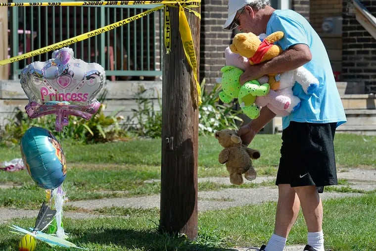 Paul Laughlin, 57, places stuffed animals on Sunday, Aug. 11, 2019 outside a home at 1248 West 11th St. in Erie, Pa., where multiple people died in an early-morning fire.