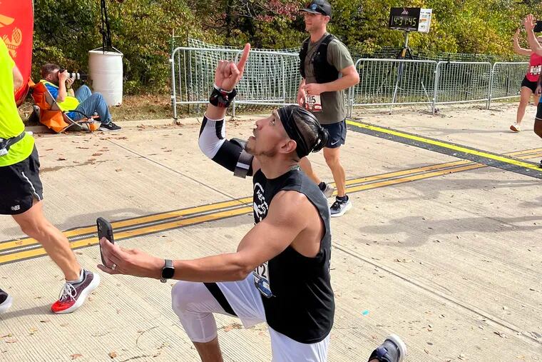 A finisher records the moment after he crossed the Marine Corps Marathon finish line on Sunday. MUST CREDIT: Washington Post photo by Bonnie Berkowitz.