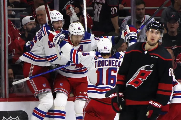 (L-R) Erik Gustafsson #56, Artemi Panarin #10 and Vincent Trocheck #16 of the New York Rangers celebrate Panarin's game-winning overtime goal against the Carolina Hurricanes in Game Three of the Second Round of the 2024 Stanley Cup Playoffs at PNC Arena on May 09, 2024 in Raleigh, North Carolina. The Rangers defeated the Hurricanes 3-2 in overtime. (Photo by Bruce Bennett/Getty Images)
