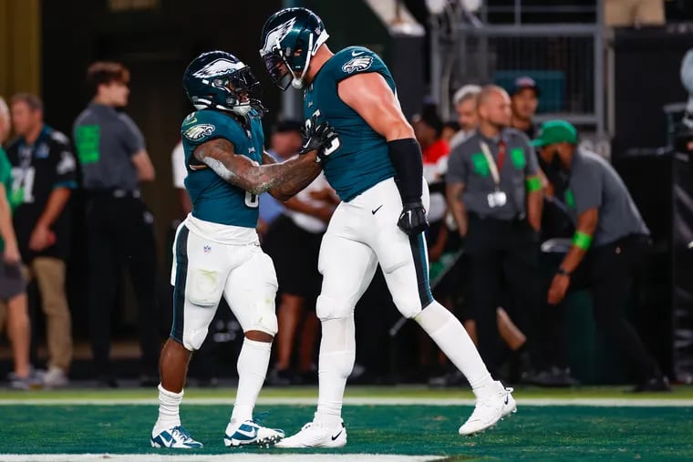 Eagles running back D'Andre Swift celebrates his 43-yard fourth-quarter run with tackle Lane Johnson.