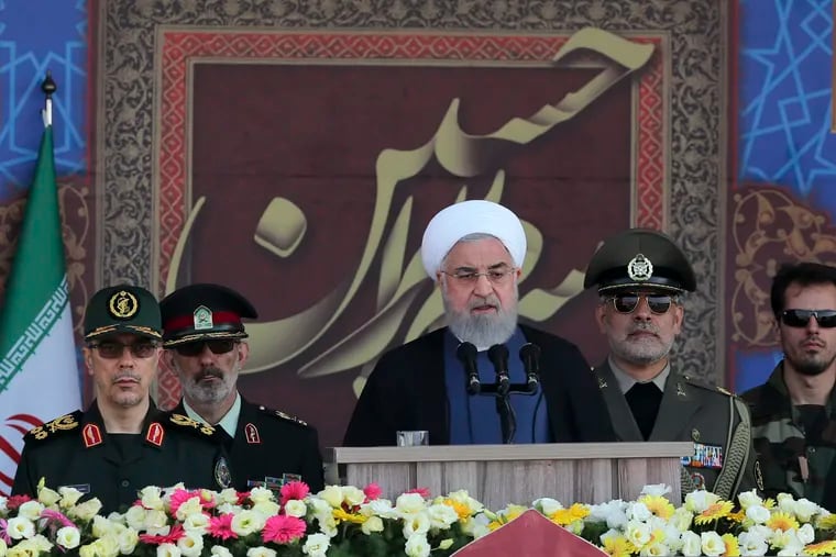 In this photo released by the official website of the office of the Iranian Presidency, President Hassan Rouhani speaks at a military parade marking 39th anniversary of outset of Iran-Iraq war, in front of the shrine of the late revolutionary founder Ayatollah Khomeini, just outside Tehran, Iran, Sunday, Sept. 22, 2019. Chief of the General Staff of the Armed Forces Gen. Mohammad Hossein Bagheri stands at left. (Iranian Presidency Office via AP)