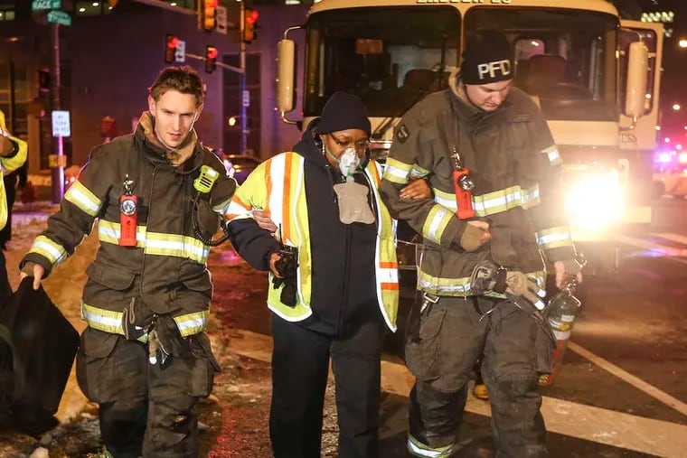 After leaving the tunnel by an escape hatch at Seventh and Race Streets, a PATCO train operator is given oxygen and escorted to a medic unit by Philadelphia firefighters.