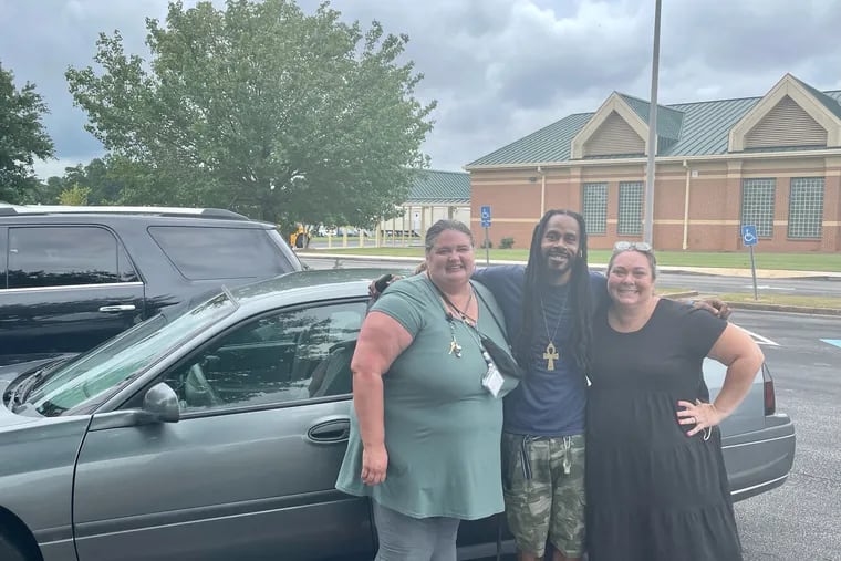 Unity Grove Elementary School teachers Megan MacDonald (left) and Jodi Combs (right) with custodian Chris Jackson after raising money to buy him a used car.