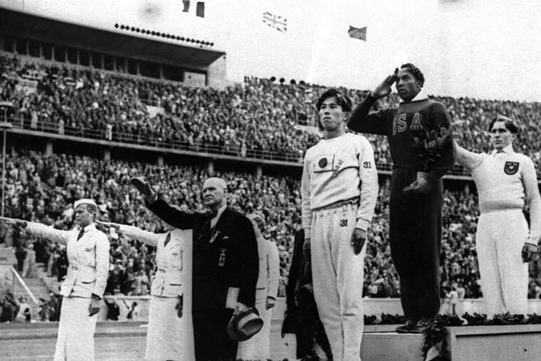 Gold medalist Jesse Owens salutes during the ceremony at the Berlin Games of 1936.