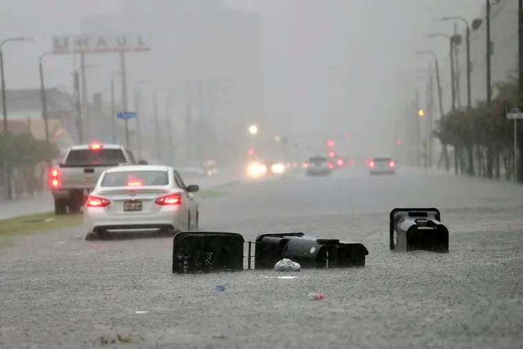 Vehicles head down a flooded Tulane Avenue in New Orleans as heavy rain from Hurricane Barry falls Wednesday in New Orleans. Moisture associated with that storm could affect the Philadelphia region on Thursday.