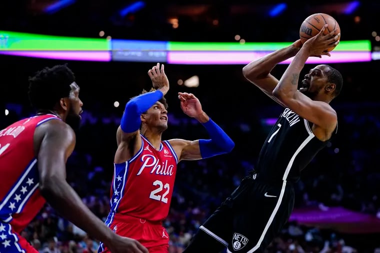 Brooklyn Nets' Kevin Durant, right, goes up for a shot against Philadelphia 76ers' Matisse Thybulle, center, and Joel Embiid during the first half of an NBA basketball game, Friday, Oct. 22, 2021, in Philadelphia. (AP Photo/Matt Slocum)