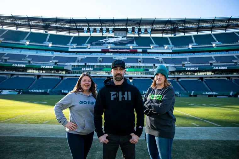 Christine Dorn, of Norristown, Pa., Graphic Designer, Sean Flanagan, of Glen Mills, Pa., Creative Director, and Loraine Griffiths, of Hammonton, N.J., Graphic Designer, pose for a group photo at the Lincoln Financial Field, in Philadelphia, Pa., on Tuesday, Jan. 11, 2022.