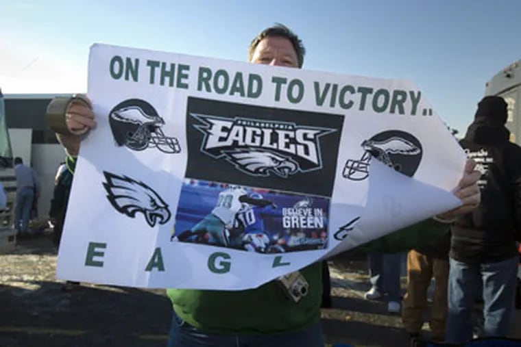 John Graber, of Levittown, Pa., holds up a road to victory Eagles sign while tailgating at the Meadowlands before last Sunday's Eagles-Giants game. (Ed Hille / Staff Photographer)
