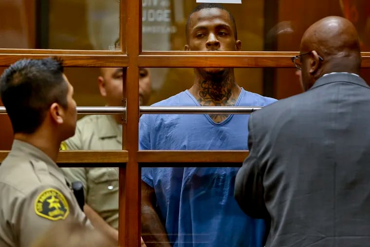 Eric Ronald Holder Jr. (center), the suspect in the killing of rapper Nipsey Hussle, is seen with his attorney, Christopher Darden (front), in Los Angeles County Superior Court Thursday, April 4, 2019.