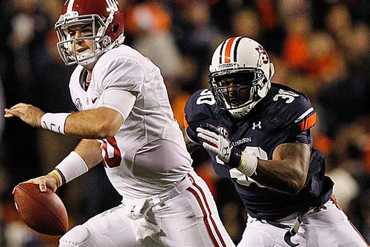 Alabama quarterback AJ McCarron is chased by Auburn defensive end Dee Ford. (Butch Dill/AP)