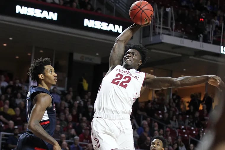 Deâ€™Vondre Perry, center, of Temple goes up for a shot between Christian Vital, left, and Tarin Smith of Connecticut during the 2nd half at the Liacouras Center on Feb. 6, 2019.