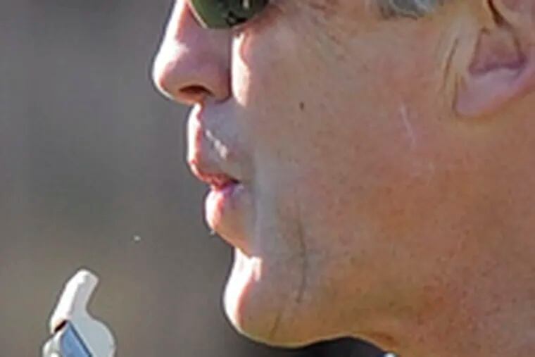 Southern Cal&#0039;s Pete Carroll spits out his whistle during practice for the Rose Bowl.