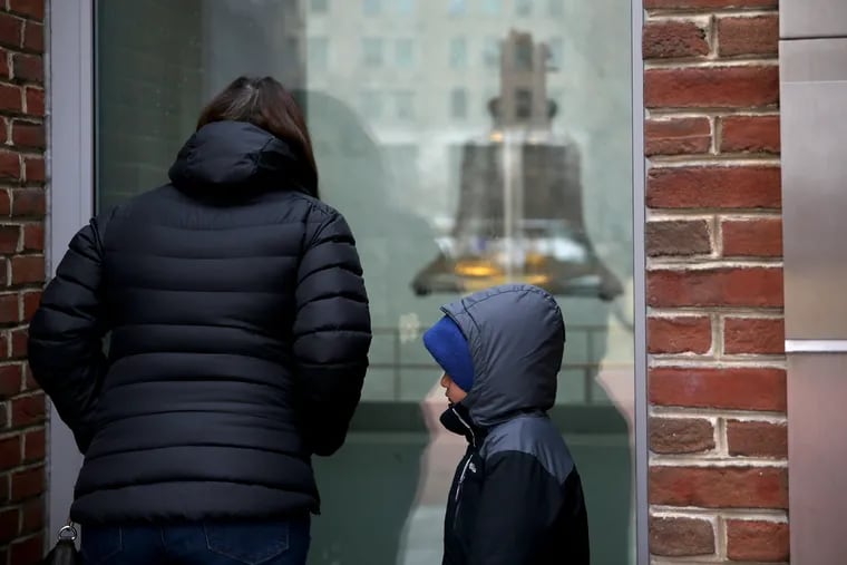 Amy Deleon of New Paltz, N.Y., and her son, Beni, 5, look at the Liberty Bell in Philadelphia through a window on Saturday, Dec. 22, 2018. The federal government — including the National Park Service — entered a partial shutdown at midnight.