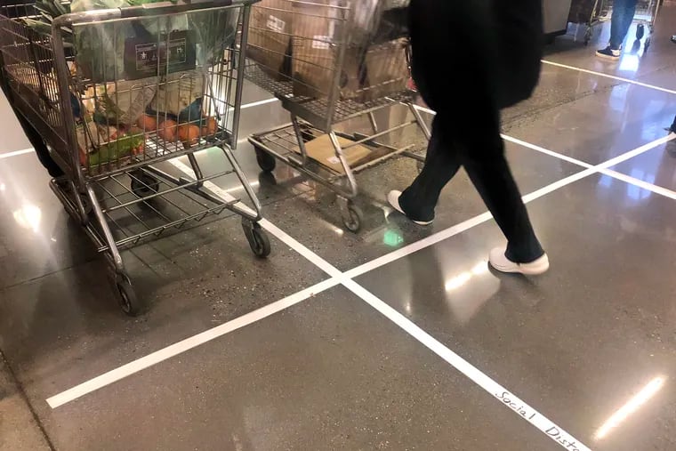 Tape on the floor reminds shoppers to stay six feet apart at the checkout counter.