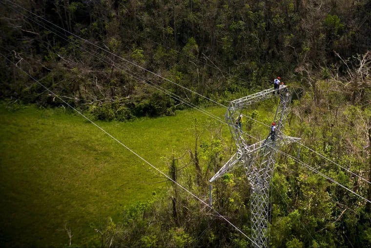 Whitefish Energy Holdings workers stand on towers to restore lines damaged by Hurricane Maria in Barceloneta, Puerto Rico, earlier this month.