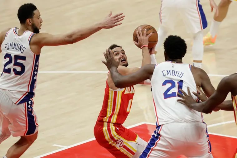 Sixers Ben Simmons and Joel Embiid defending Atlanta Hawks guard Trae Young during Game 3.