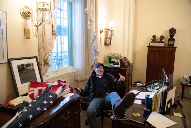 A supporter of U.S. President Donald Trump sits inside the office of U.S. Speaker of the House Nancy Pelosi.