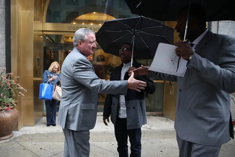 Jim Kenney shakes hands with two people as he nears his campaign headquarters. He won a shockingly easy victory on Tuesday to represent his party in the fall. (DAVID MAIALETTI/Staff Photographer)