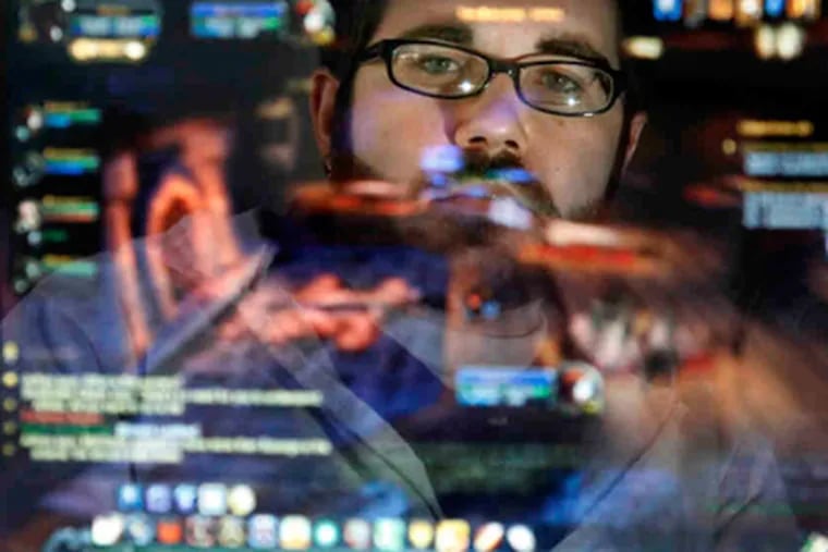 Philadelphian Joe Osborne, reflected in his monitor, has played World of Warcraft for five years, and knows gamers who lost all their "possessions" when hackers breached their account. (Laurence Kesterson / Staff Photographer)
